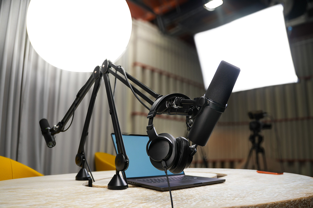 A live streaming setup with microphone, headphones, laptop, and lights